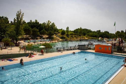 a large swimming pool with people in the water at ZEcamping 3 étoiles dog friendly avec piscine couverte et chauffée in Monclar-de-Quercy