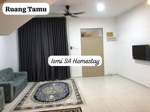 a living room with a blue chair and a rug at Ismi SA Homestay in Rawang