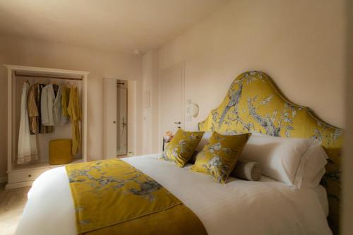 a bedroom with a large bed with yellow and blue pillows at Dimora Tre Galline in Canale
