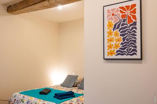 a bedroom with a bed and a painting on the wall at Le Figuier - Studio de Charme in Lavaur