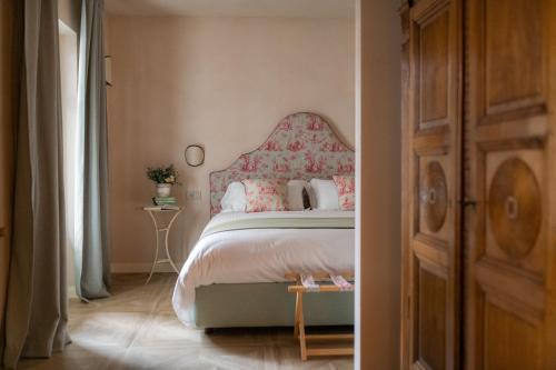 a bedroom with a bed with a pink headboard at Dimora Tre Galline in Canale