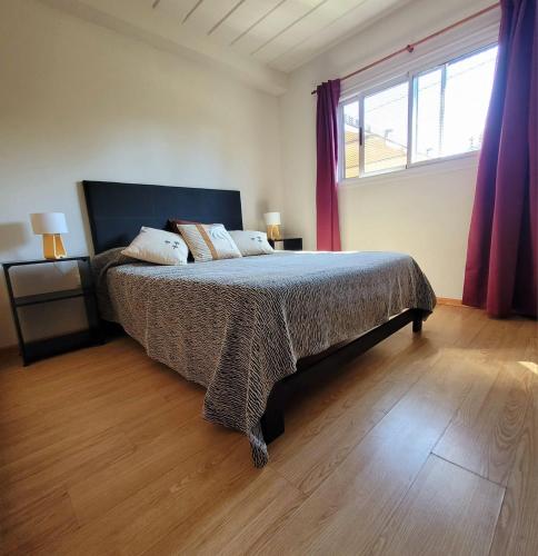 a bedroom with a bed and a large window at Palmeras del sur in Mar del Plata
