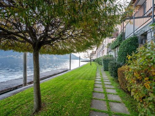 a walkway next to the water with a tree at Apartment Blu Lake by Interhome in Ghiffa