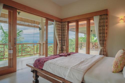 a bedroom with a bed and a balcony at Villa Le Tito in Lovina