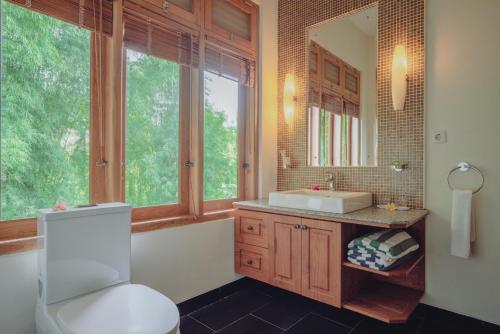 a bathroom with a toilet and a sink and a mirror at Villa Le Tito in Lovina