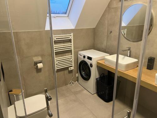 a bathroom with a washing machine and a sink at JAMY HOUSE Apartmán in Habovka