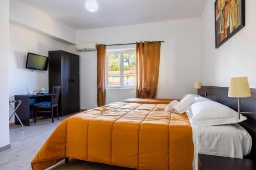 a bedroom with a bed with an orange blanket at I Tigli in Valmontone