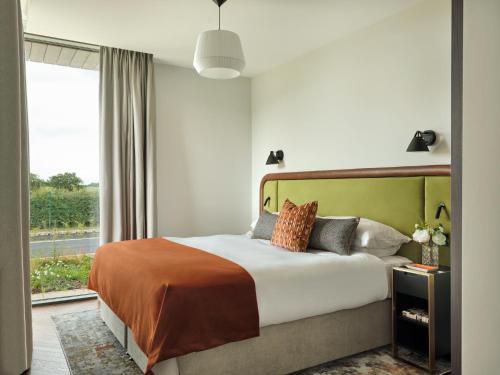 ein Schlafzimmer mit einem großen Bett und einem Fenster in der Unterkunft Escapade Silverstone in Towcester