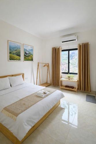 a bedroom with a large bed and a large window at De Pakha Homestay in Bắc Hà