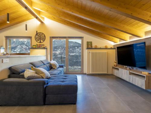 a living room with a blue couch and a flat screen tv at Villa Cech Coast House by Interhome in Civo