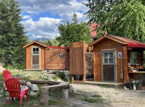a wooden cabin with a red chair in front of it at Funky Bunky in Nelson