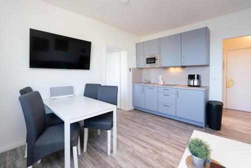 a kitchen and dining room with a white table and chairs at Solymar Whg 64 in Grömitz