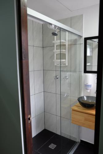 a bathroom with a shower, sink, and mirror at Ivy Hostel in Medellín