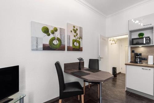a dining room with a table and a kitchen at Solymar Whg 11 in Grömitz
