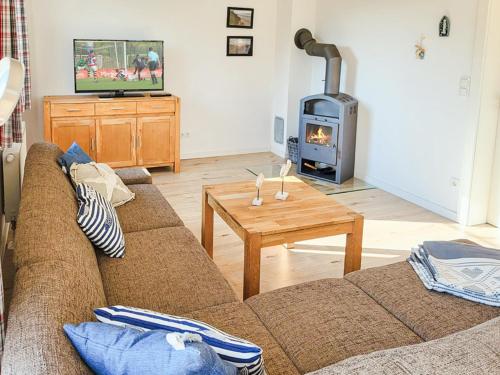 a living room with a couch and a wood stove at Ferienhaus Kranichnest in Breege