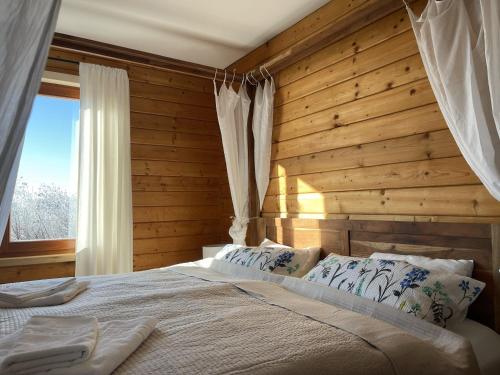 a bedroom with a bed with a wooden wall at Waldmarie in Grafenau