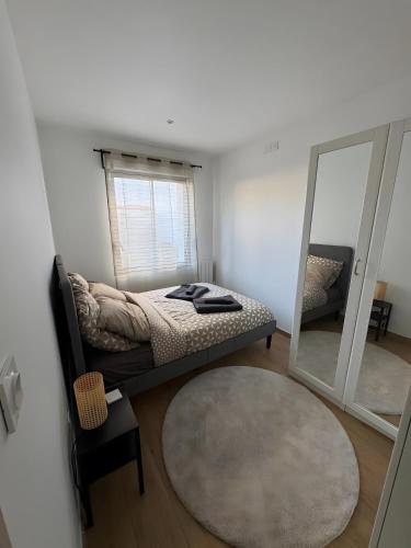a bedroom with a bed and a mirror at Maison de Vacances Mon Cocon Bordelais in Villenave-dʼOrnon