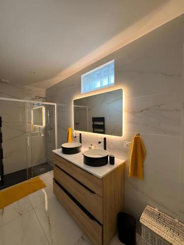 a bathroom with two sinks and a mirror at Maison de Vacances Mon Cocon Bordelais in Villenave-dʼOrnon
