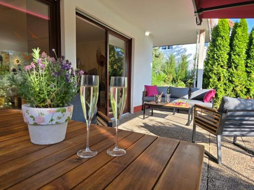 two wine glasses sitting on top of a wooden table at Exklusive Ferienwohnung Bad Salzschlirf - direkt am Waldrand - großer Garten kompett umzäunt - Hunde willkommen - 2 private Stellplätze in Bad Salzschlirf