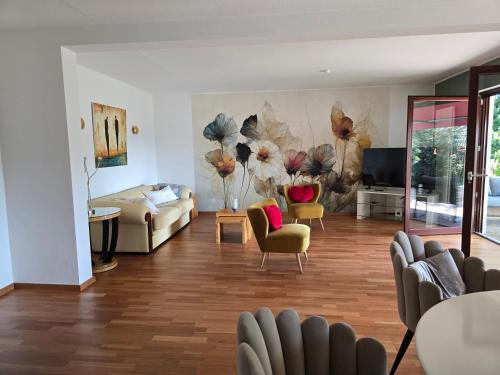 a living room with a large painting on the wall at Exklusive Ferienwohnung Bad Salzschlirf - direkt am Waldrand - großer Garten kompett umzäunt - Hunde willkommen - 2 private Stellplätze in Bad Salzschlirf