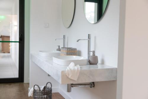 a bathroom with two sinks and a mirror at Raposa Verde - Agroturismo in Pegarinhos