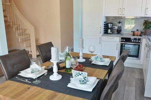 a dining room with a table and chairs and a kitchen at Haus Fischerstraße 6a in Grömitz
