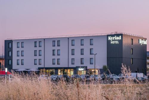 a hotel building with cars parked in a parking lot at Kyriad Chateauroux Nord - Aéroport in Déols