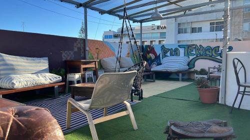 a patio with chairs and a swing on a roof at RIA Terrace in Faro