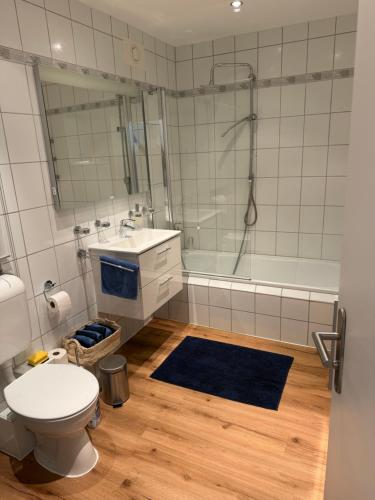 a bathroom with a toilet and a sink and a tub at BeachPark Sierksdorf in Scharbeutz
