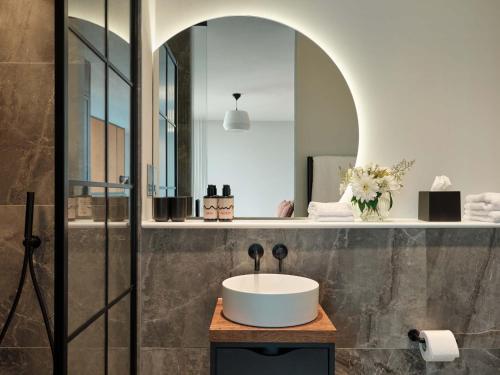 ein Badezimmer mit Waschbecken und Spiegel in der Unterkunft Escapade Silverstone in Towcester