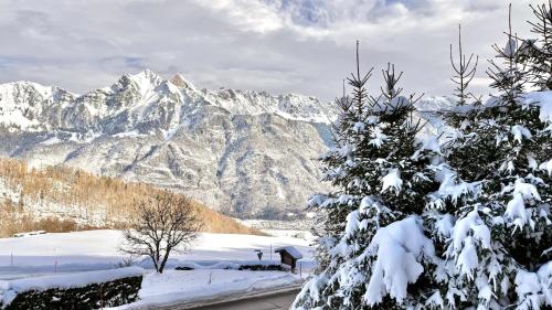 a snow covered mountain range with a snow covered tree at INN JOY Apartments - Flumserberg mit Bergpanorama in Flums