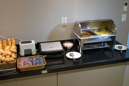 a kitchen with a counter with bread and pastries at Hotel Vila Verde in Penápolis