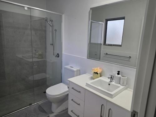 a bathroom with a toilet and a sink and a shower at Cozy Retreat - 3 Bedroom House in Perth