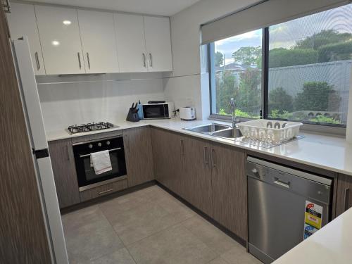 a kitchen with a sink and a stove and a window at Cozy Retreat - 3 Bedroom House in Perth