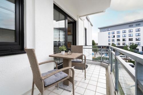 a balcony with a table and chairs on a building at Titania Whg 10 in Grömitz
