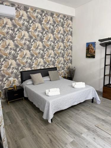 a bedroom with a large bed with a floral wallpaper at B&B Melissa in Noto