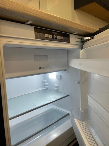 an empty refrigerator with its door open at Weymouths Coastal Nook in Weymouth