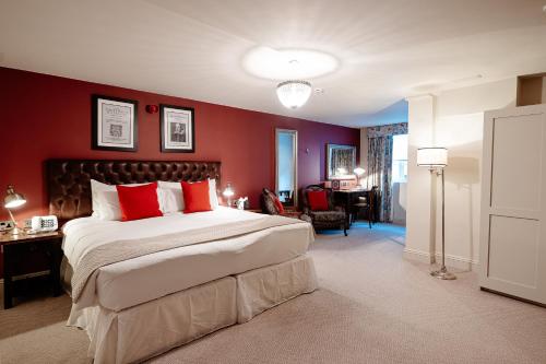 a bedroom with a large bed with red walls at The White Swan Hotel in Stratford-upon-Avon