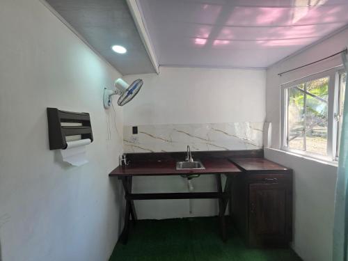 a small bathroom with a sink and a window at HOUSEWAVe in Parrita