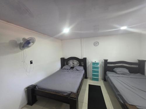 a bedroom with two twin beds and a fan at HOUSEWAVe in Parrita