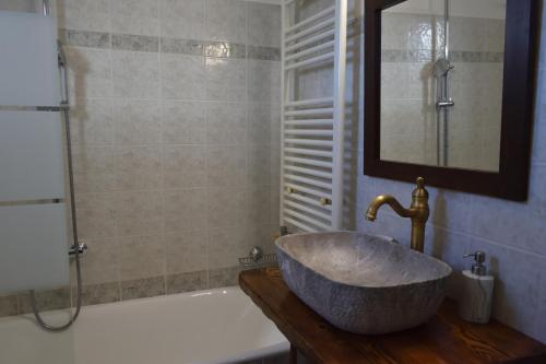 a bathroom with a large stone sink and a tub at Holiday Cottage in Lílaia