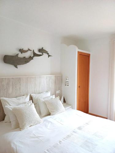 a bedroom with a white bed with white pillows at Casa Ocean in Carvoeiro