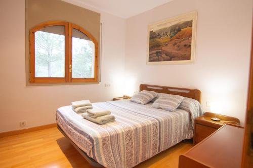 a bedroom with a bed with towels on it at La Vinya de Mas Pujol in Suria