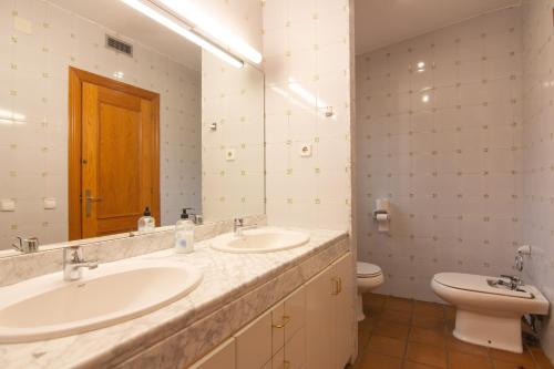 a bathroom with two sinks and a toilet at La Vinya de Mas Pujol in Suria