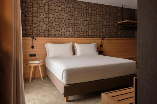 a bedroom with a white bed and a wooden wall at Il Leon D'Oro Bari - by Farace Hotels in Bari