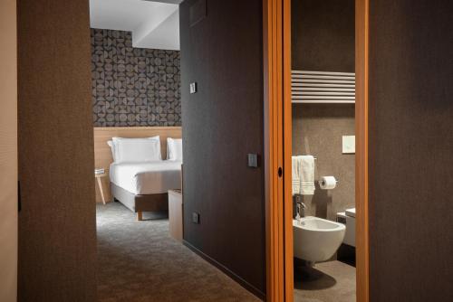 a hotel room with a bed and a bathroom at Il Leon D'Oro Bari - by Farace Hotels in Bari
