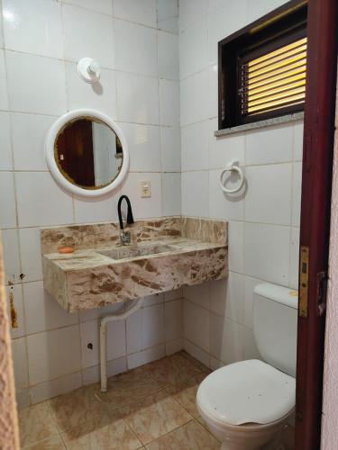 a bathroom with a sink and a toilet and a mirror at Nascimento BEACH in Águas Belas