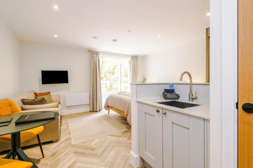 a kitchen with a sink and a living room at Rock Mill - Deluxe Apartments with Private Terrace in Stony Middleton