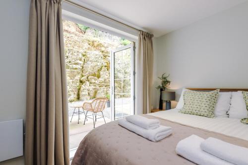 a bedroom with a bed and a large window at Rock Mill - Deluxe Apartments with Private Terrace in Stony Middleton