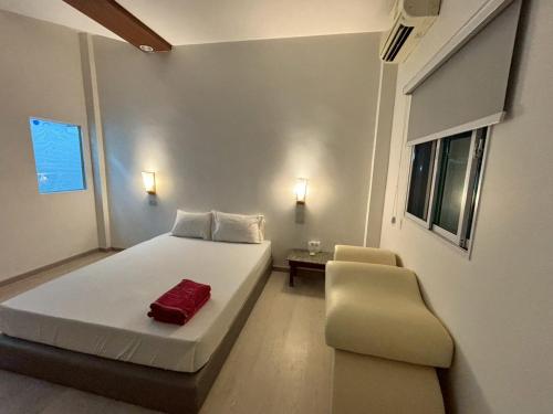a small bedroom with a bed and a chair at Picnic Si Racha in Ban Fang Daeng